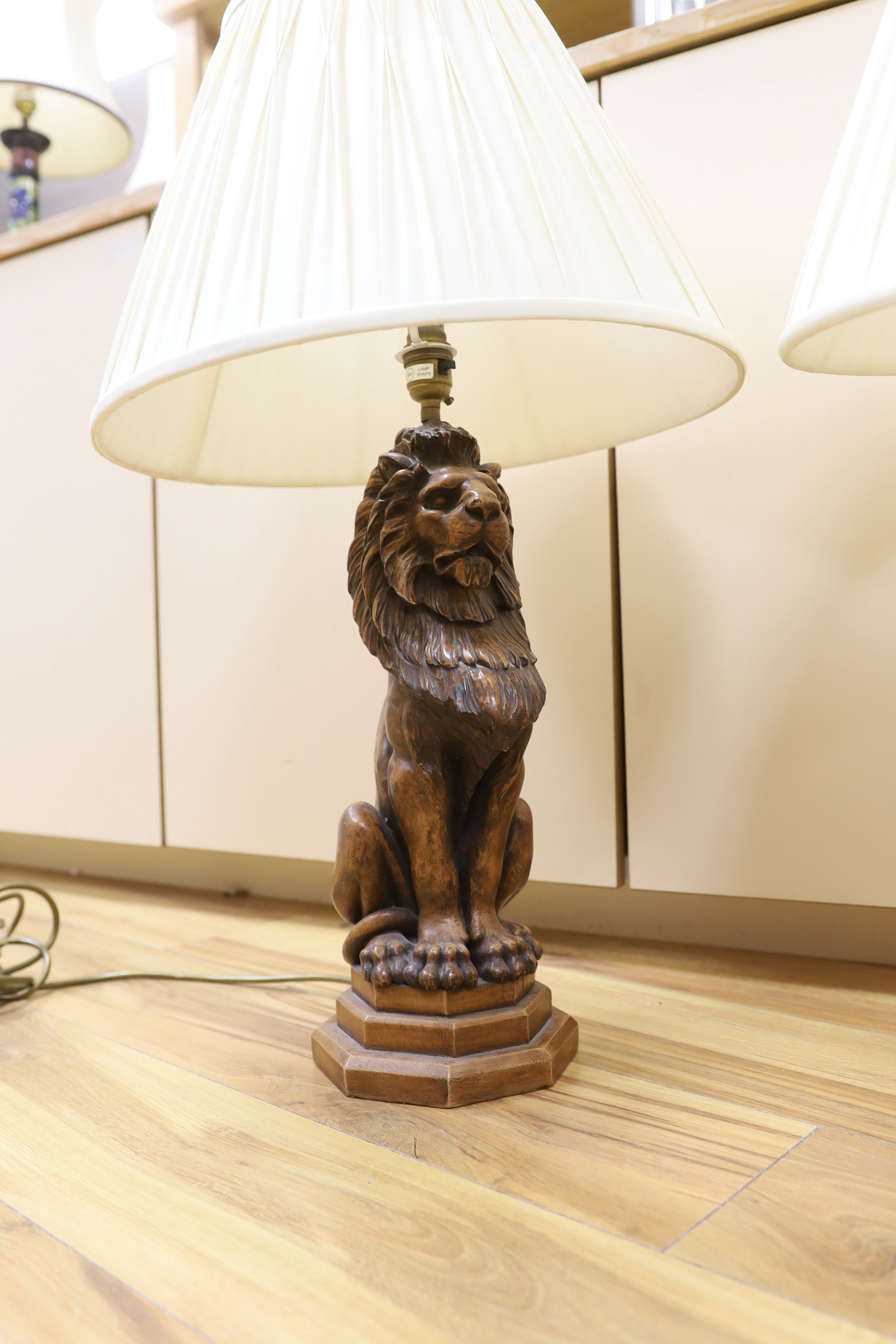 A pair of faux carved lion table lamps, 65cm high including shades